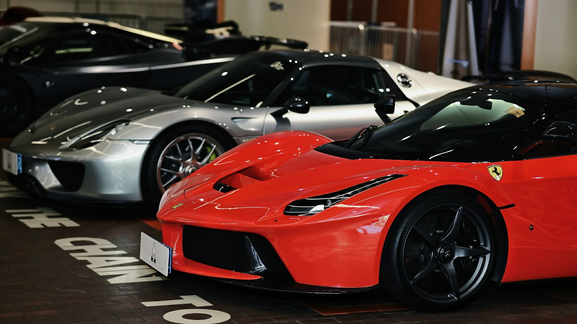 Several luxury sports cars parked in a row.